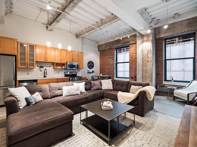 living room with a high ceiling and beamed ceiling