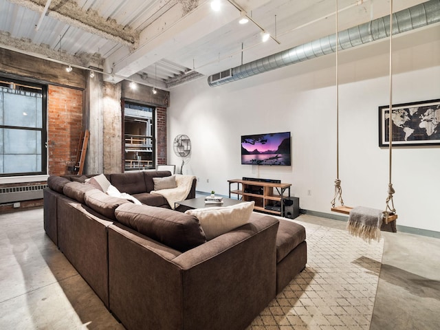 living room with beam ceiling, radiator heating unit, and track lighting