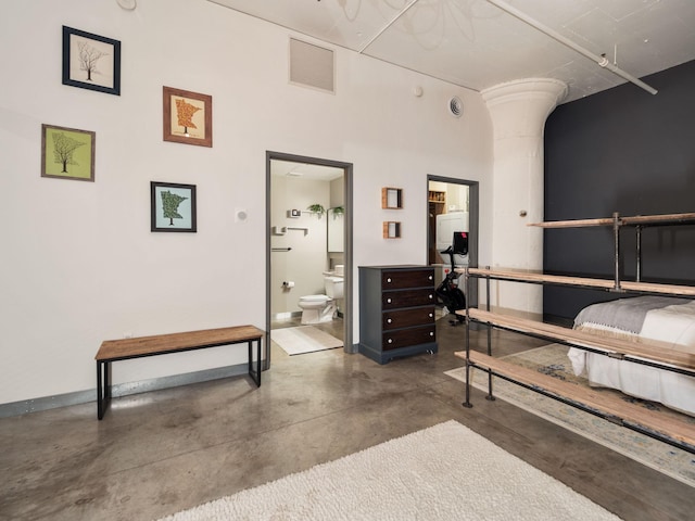 bedroom featuring ensuite bath and a high ceiling