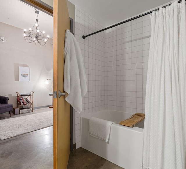 bathroom featuring shower / bath combination with curtain, a notable chandelier, and concrete flooring