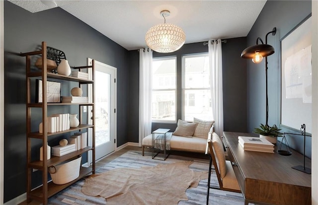 office area with light wood-type flooring and an inviting chandelier