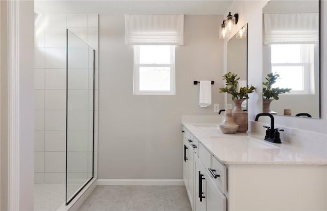 bathroom with tile patterned floors, tiled shower, and vanity