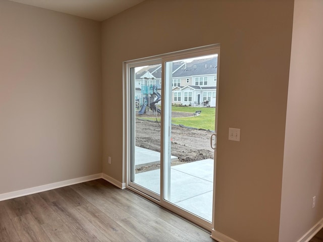 doorway to outside with light wood finished floors and baseboards