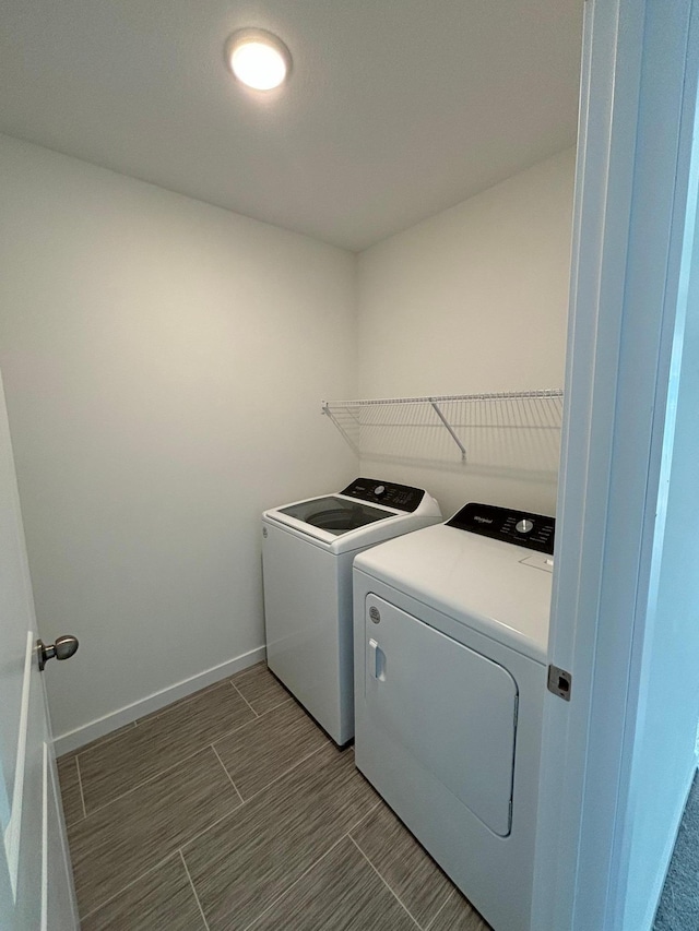 clothes washing area featuring washing machine and dryer, laundry area, and baseboards