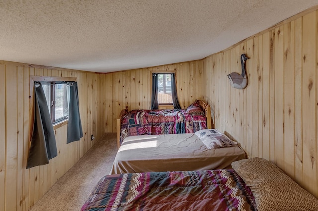 bedroom featuring wooden walls, a textured ceiling, and carpet flooring