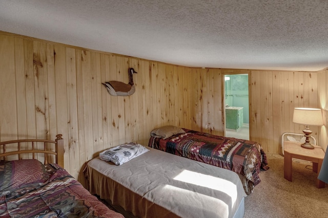 bedroom with wood walls, a textured ceiling, and carpet flooring