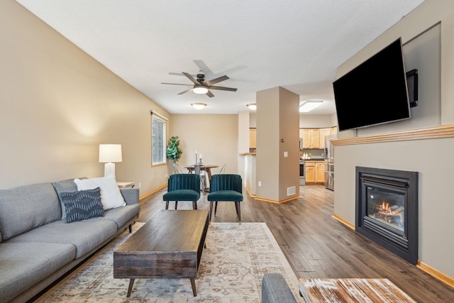 living room with ceiling fan and wood-type flooring