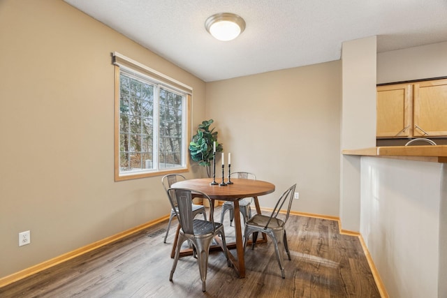 dining area featuring a textured ceiling and dark hardwood / wood-style floors