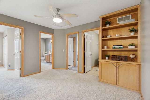 hallway with light carpet and a textured ceiling