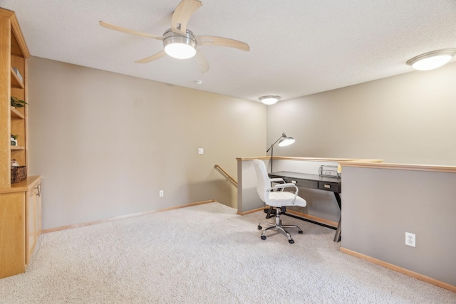 carpeted home office featuring ceiling fan and a textured ceiling