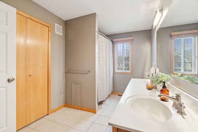 bathroom featuring a textured ceiling, tile patterned floors, and vanity