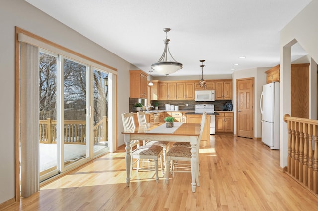 dining space featuring baseboards, light wood-style flooring, and recessed lighting