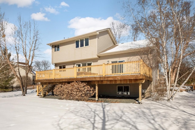 snow covered property with stairway and a deck