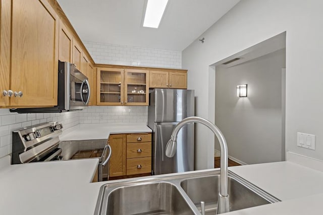 kitchen featuring backsplash, stainless steel appliances, and sink