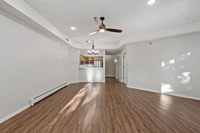 unfurnished living room featuring ceiling fan with notable chandelier, dark hardwood / wood-style floors, and baseboard heating