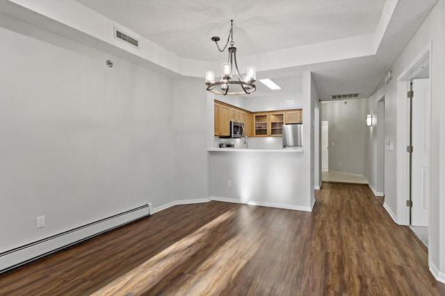 interior space featuring a raised ceiling, dark wood-type flooring, a chandelier, and baseboard heating