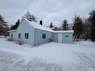 view of snow covered back of property