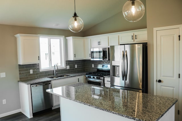 kitchen featuring backsplash, white cabinets, dark stone counters, appliances with stainless steel finishes, and sink