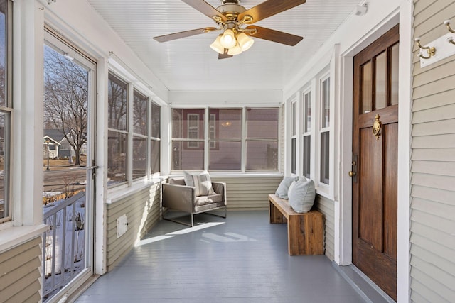 unfurnished sunroom featuring ceiling fan