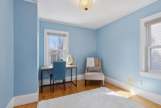 living area featuring crown molding, wood finished floors, and baseboards