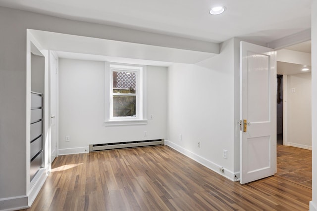 unfurnished bedroom featuring recessed lighting, wood finished floors, baseboards, and baseboard heating