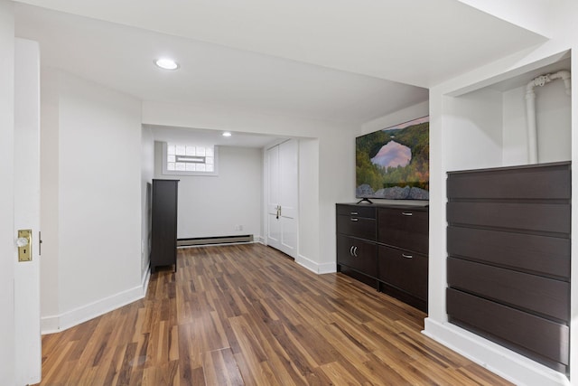 below grade area with recessed lighting, dark wood-type flooring, baseboards, and a baseboard radiator