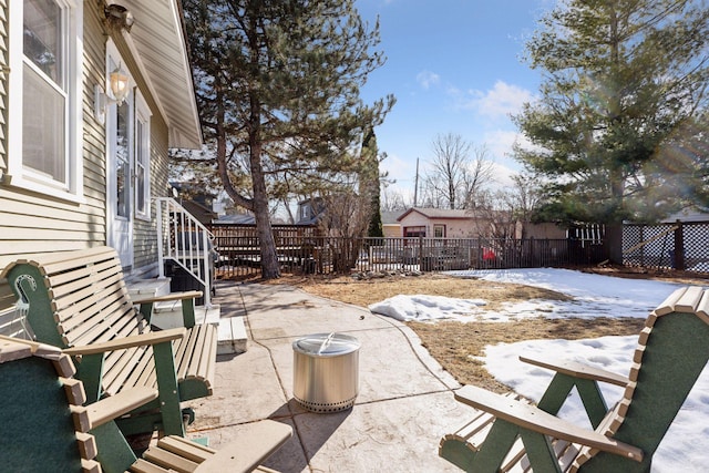 snow covered patio featuring a fenced backyard