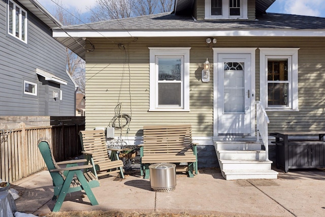 exterior space with a patio, a shingled roof, and fence