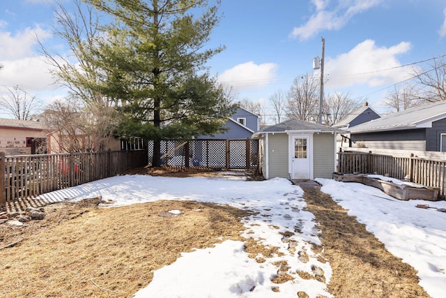 snow covered property with an outbuilding and a fenced backyard