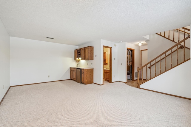 unfurnished living room featuring light colored carpet and a textured ceiling