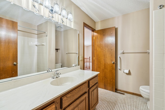 bathroom featuring toilet, a shower, a textured ceiling, vanity, and tile patterned flooring