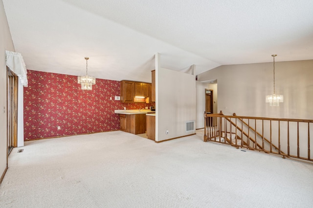 interior space with lofted ceiling, wallpapered walls, light carpet, and a chandelier