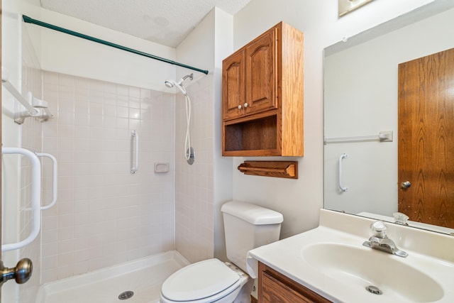 bathroom with a textured ceiling, vanity, a shower stall, and toilet