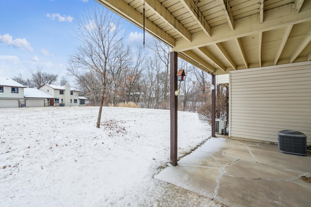 yard covered in snow with a garage and cooling unit