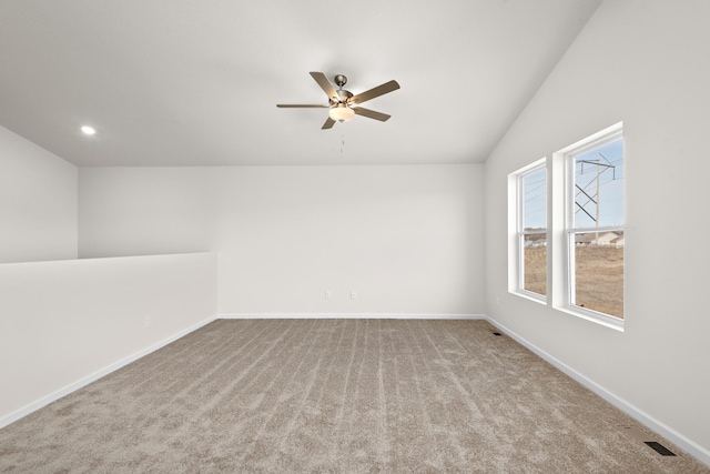 empty room featuring vaulted ceiling, ceiling fan, and light carpet