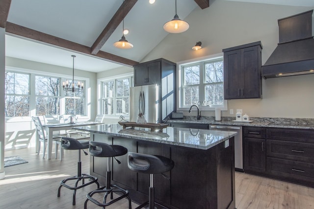 kitchen with stone counters, appliances with stainless steel finishes, custom exhaust hood, and a kitchen island