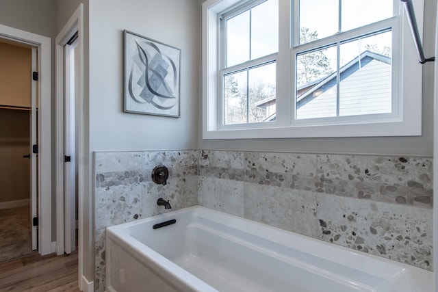 bathroom featuring wood-type flooring and a bath