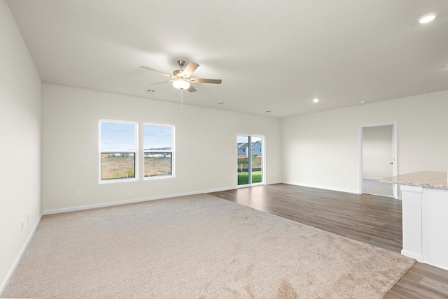 spare room with ceiling fan, plenty of natural light, and carpet flooring