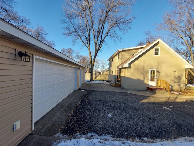 snow covered property with a garage