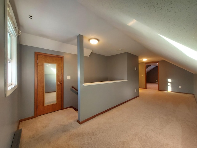 bonus room featuring lofted ceiling and carpet flooring