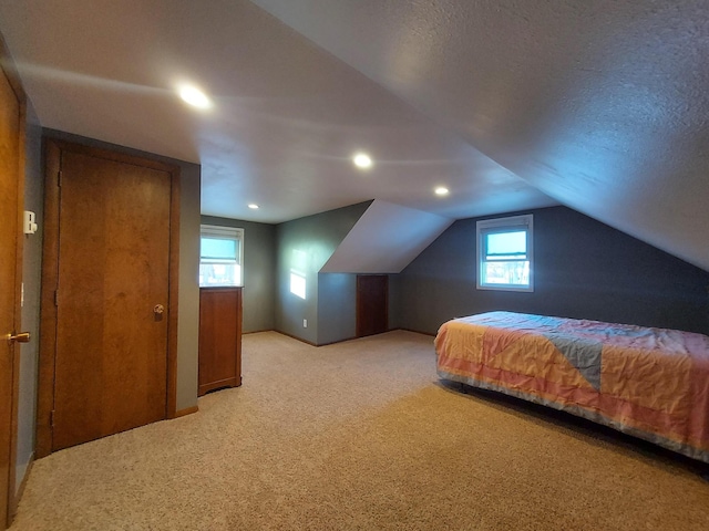 carpeted bedroom with vaulted ceiling