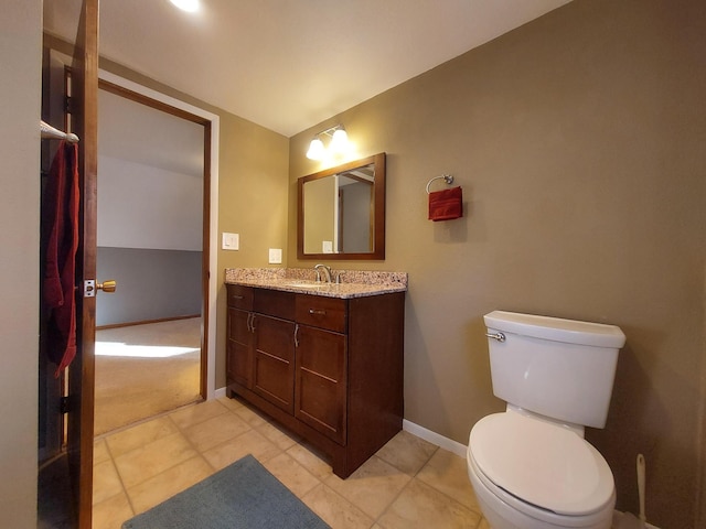 bathroom with toilet, vanity, and tile patterned floors