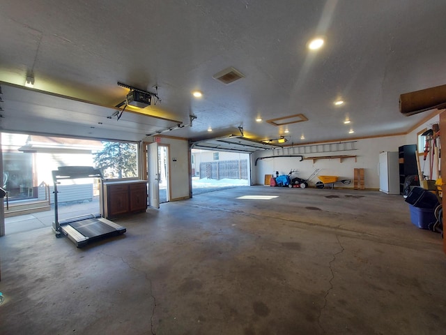 garage with white refrigerator and a garage door opener