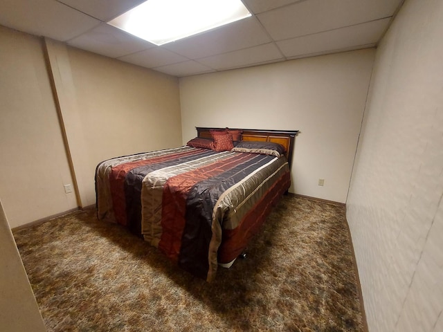 carpeted bedroom featuring a drop ceiling