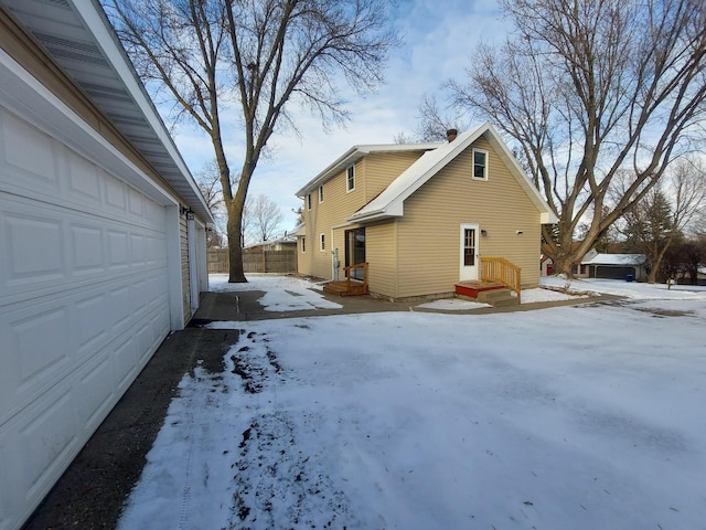 snow covered property with a garage