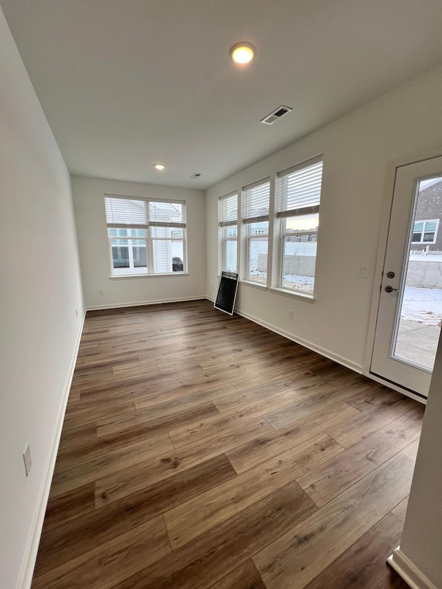 unfurnished living room featuring hardwood / wood-style flooring and a healthy amount of sunlight