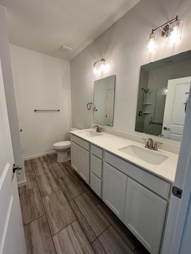 bathroom featuring walk in shower, vanity, and toilet