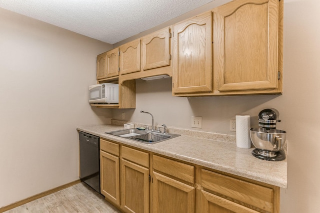 kitchen featuring sink, dishwasher, light hardwood / wood-style floors, a textured ceiling, and light brown cabinets