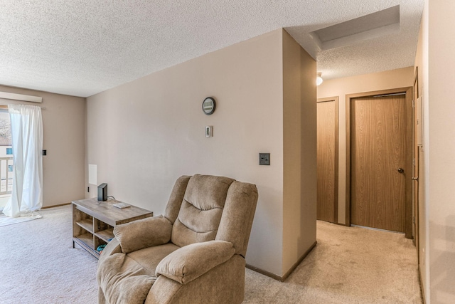 sitting room featuring light colored carpet and a textured ceiling