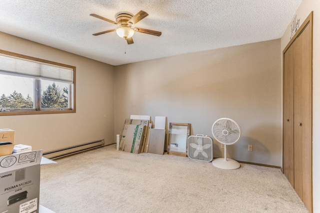 miscellaneous room featuring ceiling fan, a baseboard radiator, carpet flooring, and a textured ceiling